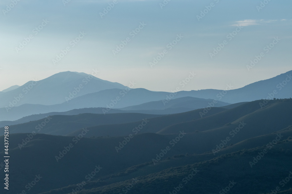 Fototapeta premium A view of the landscape, in which the mountain hills are in the morning haze of fog