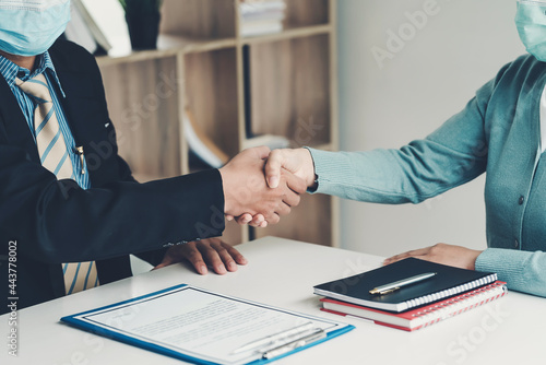 Businessman and customer shaking hand agreement to work together successfully at the office. Wear a mask