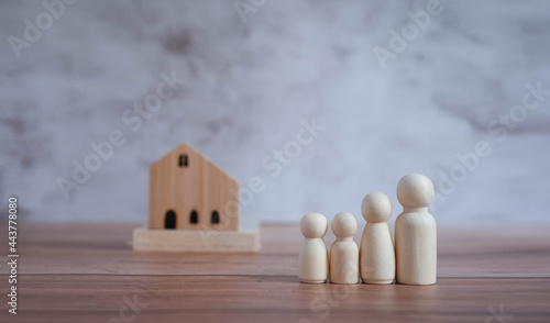 Mini wood house model and wooden figure of people in family include parents and children on wood table,Planning buy Real Estate and property and Choose the best.Work from home and stay home concept.