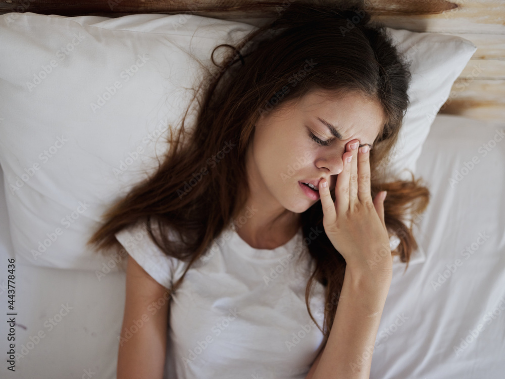 woman lying in bed with closed eyes displeased facial expression woman lying in bed with closed eyes displeased facial expression