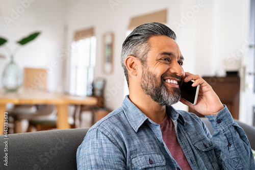 Happy mid indian man talking on phone