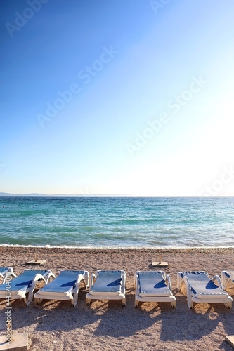 Deck chairs arranged on a beautiful beach near Split, Croatia. Selective focus. © jelena990