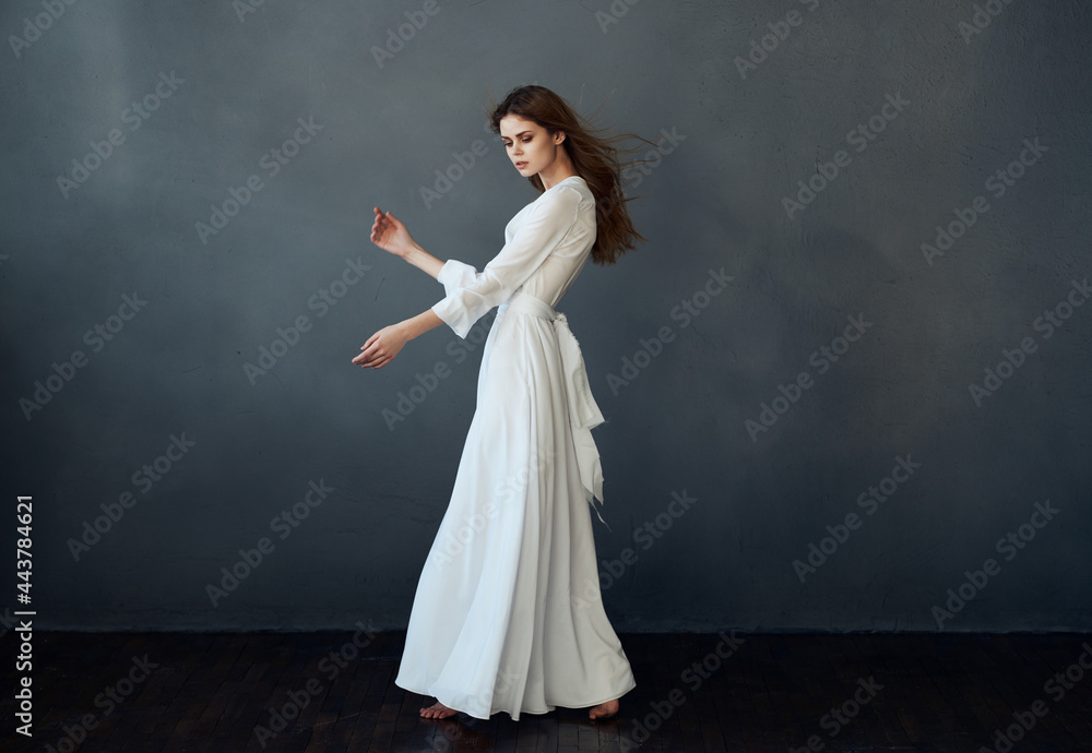 woman in full length dress posing dance dark background