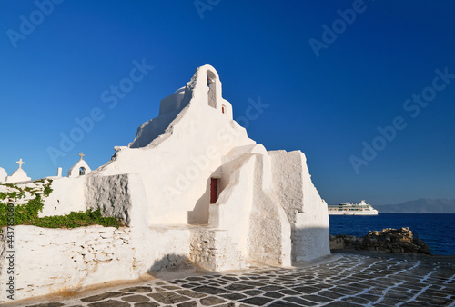 Famous tourist landmark, Mykonos, Greece. White Greek Orthodox church of Panagia Paraportiani, town of Chora on island at sunrise. Iconic destination photo