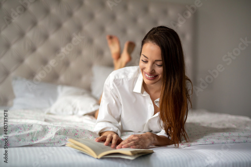 Beautiful young woman relaxing reading book at home