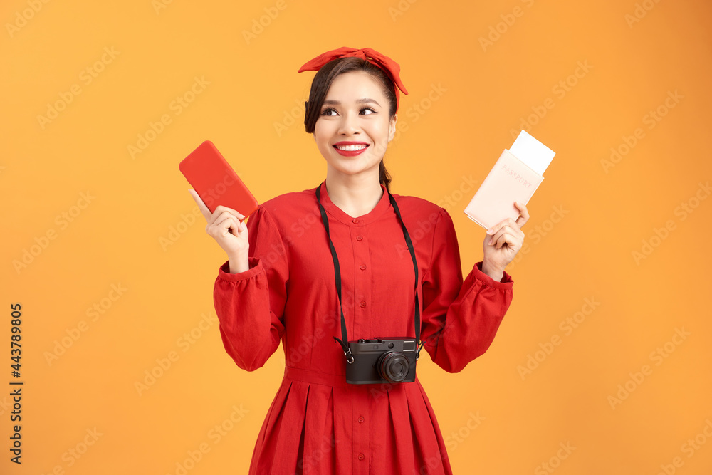 Happy woman tourist travel holding camera and passport isolated on yellow background, asian Happy woman tourist travel holding camera and passport isolated on yellow background, asian