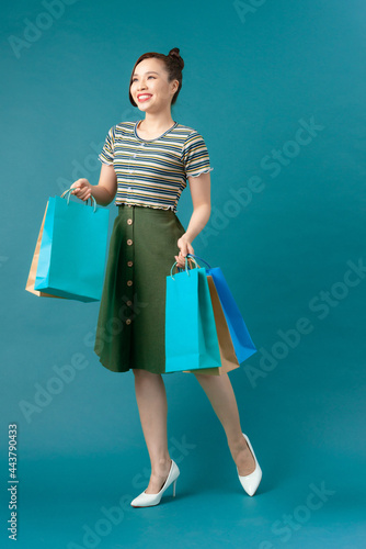 An attractive fashionable woman holding colorful paper shopping bags © makistock