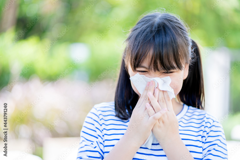 Little girl Asians sneezing in the garden. Little girl Asians sneezing in the garden.