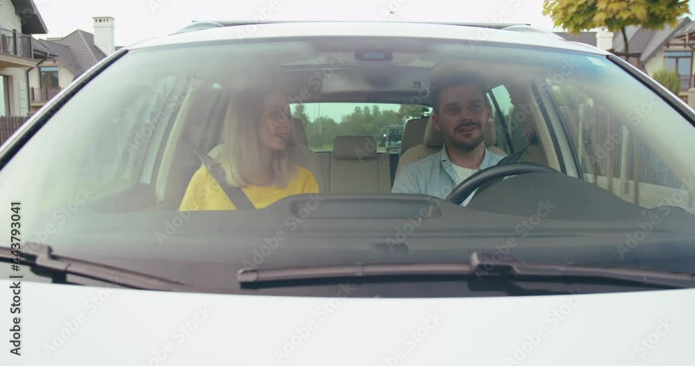 Cheerful couple chatting and laughing while traveling by car while spending leisure time together and preparing to the great adventure. Transport concept Cheerful couple chatting and laughing while traveling by car while spending leisure time together and preparing to the great adventure. Transport concept
