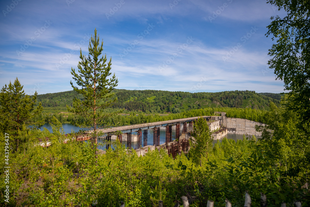 Fototapeta premium View of abandoned hydroelectric power plant on the Taidon River in Siberia, Russia