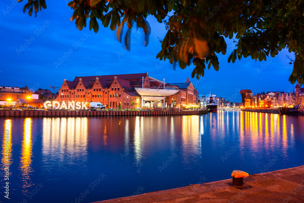 Obraz premium Beautiful scenery of Gdansk city at dusk over the Motlawa river with illuminated Gdansk inscription. Poland
