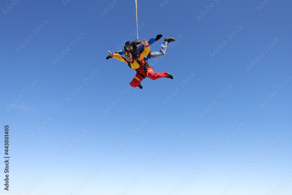 Skydiving. Tandem jump. A happy passenger and her instructor are flying in the sky. Skydiving. Tandem jump. A happy passenger and her instructor are flying in the sky.