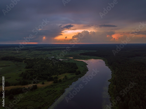 Beautiful, fascinating sunset with clouds over a lake, a river on a summer evening, view from a drone