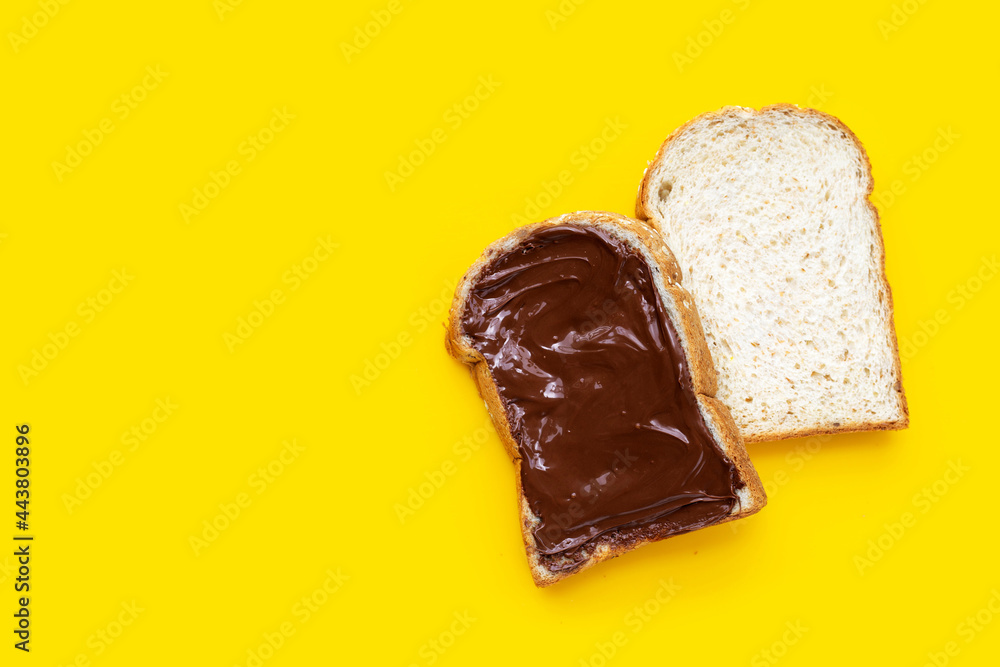 Bread with sweet chocolate hazelnut on yellow background. Bread with sweet chocolate hazelnut on yellow background.