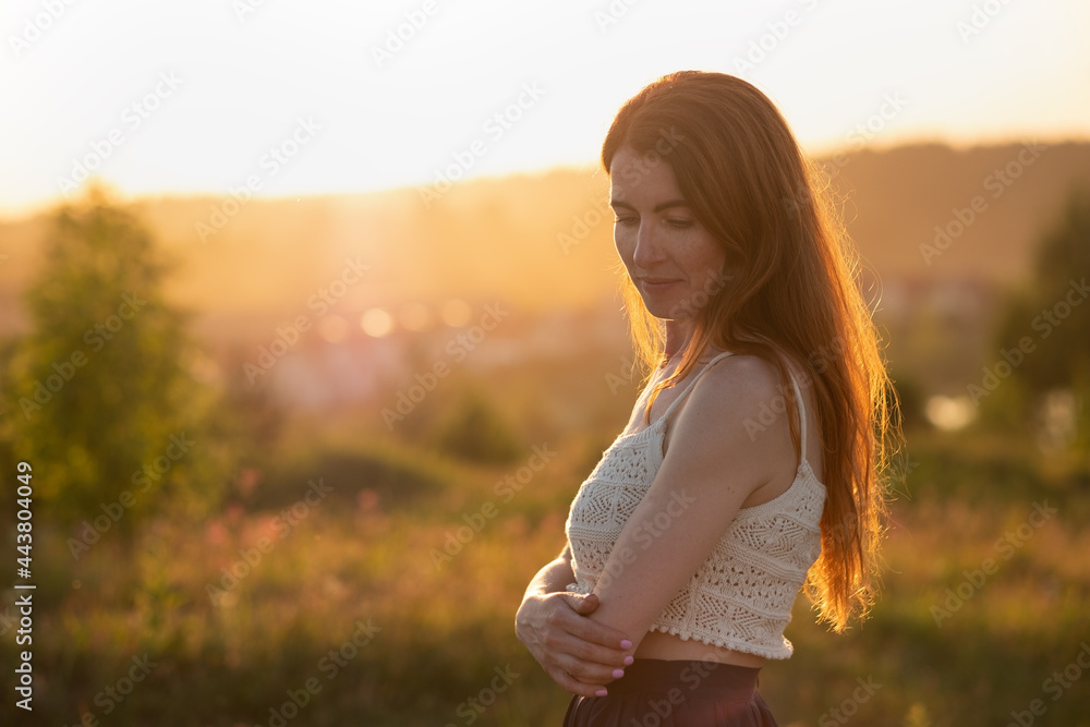 Happy woman smiling and looking down on summer field Happy woman smiling and looking down on summer field