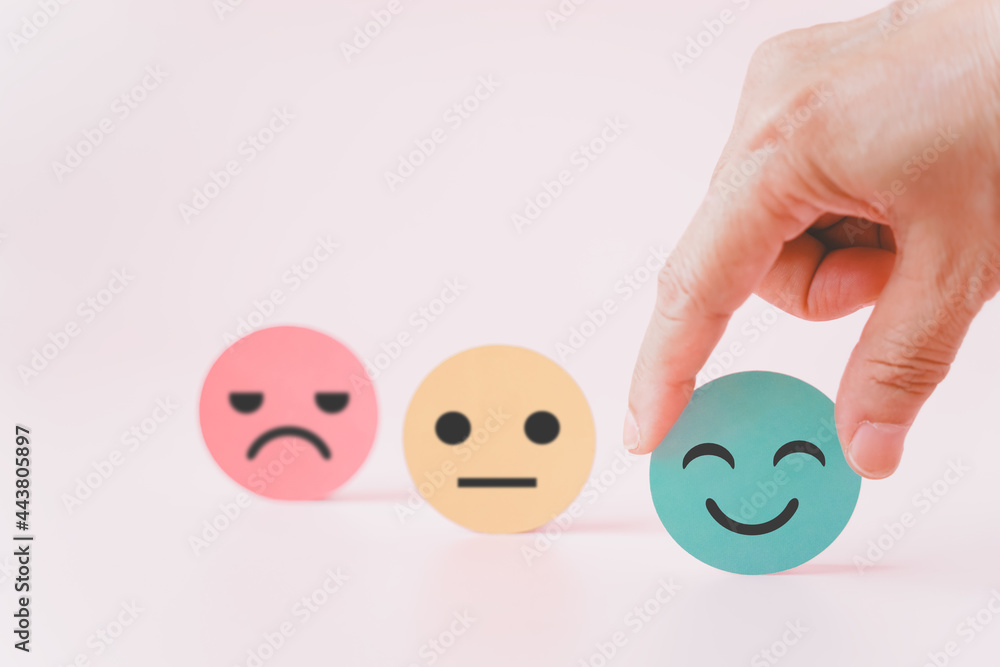 hand choose green paper cut, happy smiling face for mental health assessment ,positive thinking, world mental health day ,customer review, experience, satisfaction survey concept hand choose green paper cut, happy smiling face for mental health assessment ,positive thinking, world mental health day ,customer review, experience, satisfaction survey concept