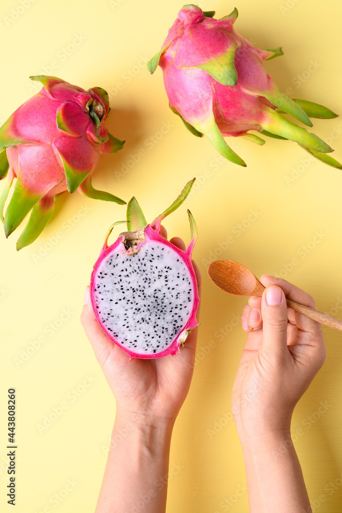 Dragon fruit or pitaya holding by woman hand with spoon for eating on yellow background, Tropical fruit Dragon fruit or pitaya holding by woman hand with spoon for eating on yellow background, Tropical fruit