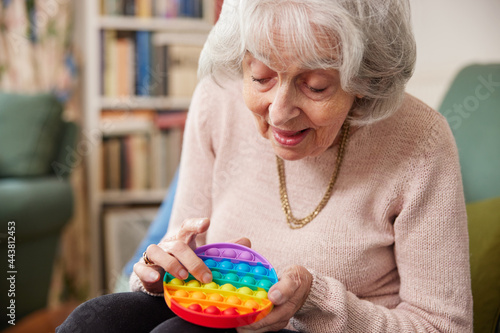 Senior Woman Using Colourful Fidget Toy To Improve Mental Stimulation At Home photo