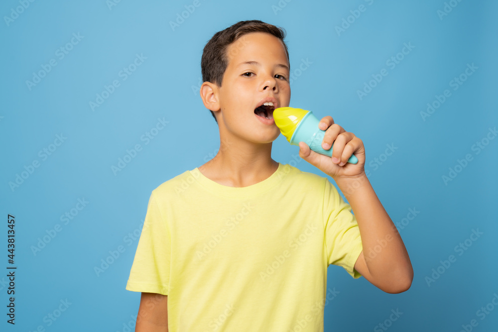 Adorable boy with ice cream against blue background Adorable boy with ice cream against blue background