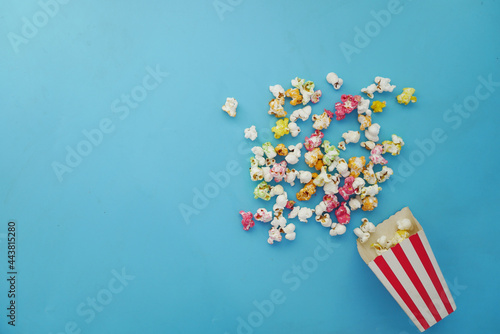  popcorn spilling from a paper container on wooden background 