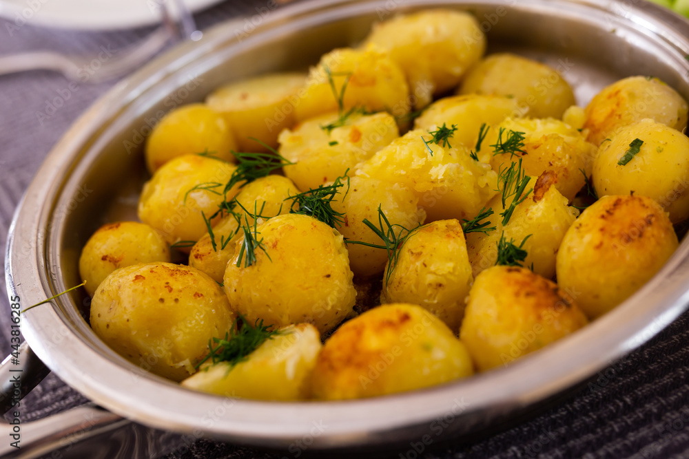 toasted young potatoes with dill in metal skillet toasted young potatoes with dill in metal skillet
