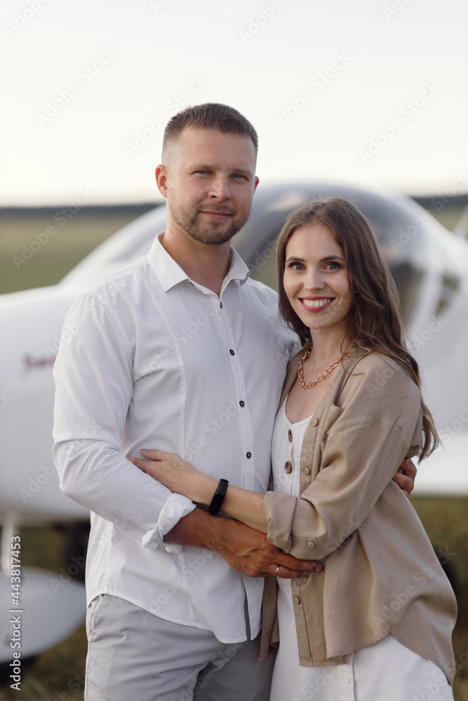 A couple of lovers, in the cockpit on their own plane. Smiling people and a private plane in the background. A couple of lovers, in the cockpit on their own plane. Smiling people and a private plane in the background.