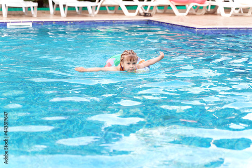 child girl with an inflatable ring in the swimming pool