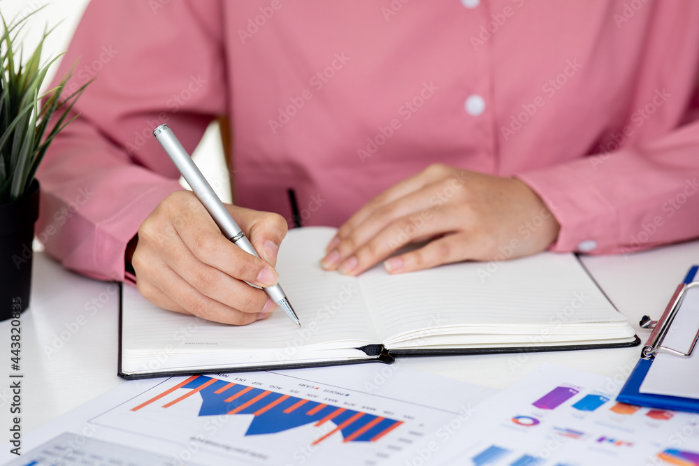 An Asian female is taking notes on her notebook for online classes, study ideas and note-taking. An Asian female is taking notes on her notebook for online classes, study ideas and note-taking.