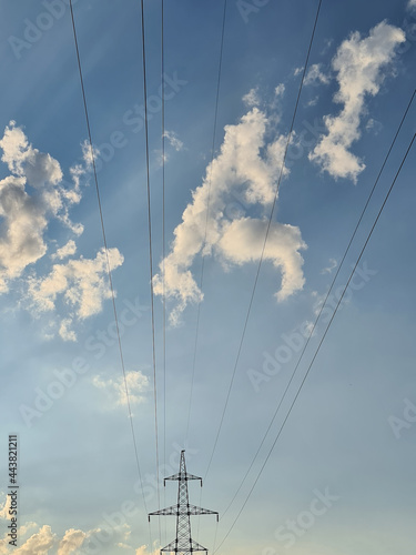 Electric wires from power lines on background of blue sky with clouds
