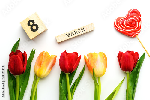 Yellow and red tulips, lollipop and the inscription on March 8 isolated on white background. Spring and summer backdrop. International Women's Day