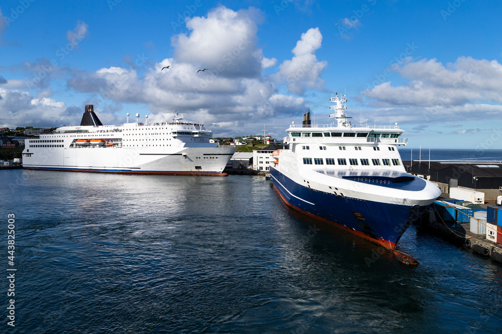 The photo shows two large ferries on the island of Orkney, tied up to a pier