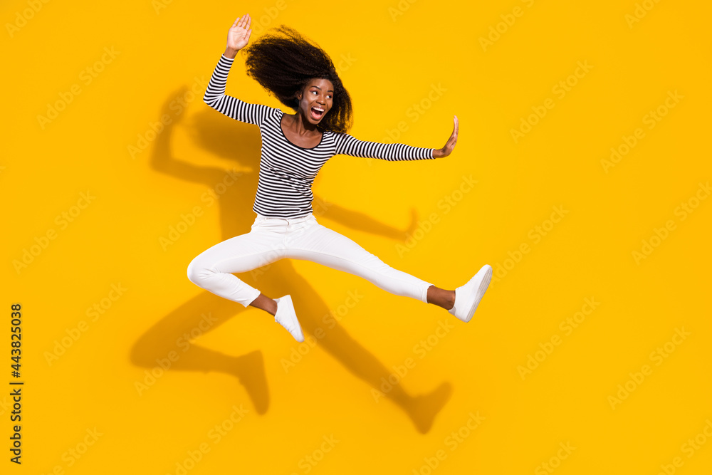 Full length body size photo woman in white pants practicing karate kicking with leg isolated vibrant yellow color background