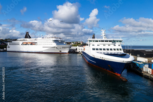 The photo shows two large ferries on the island of Orkney, tied up to a pier