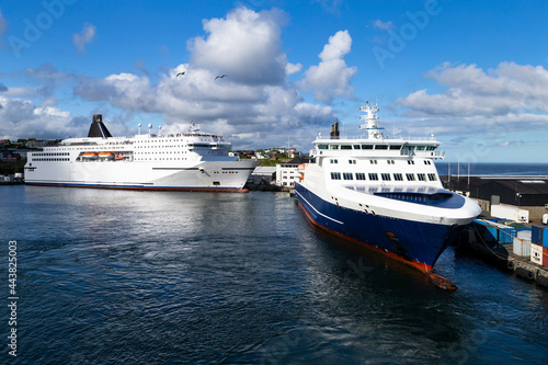 The photo shows two large ferries on the island of Orkney, tied up to a pier photo