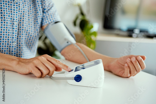 measuring his blood pressure at home