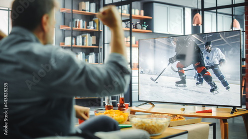 Photography At Home Ice Hockey Fans Sitting on a Couch Watch Game on TV, Cheer when Favourtite Sports Team to Win the Championship