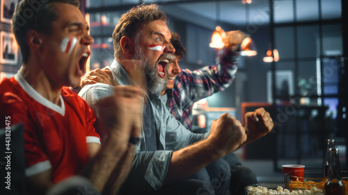 Canvas Print At Home Three Joyfuls Sports Fans with Painted Faces Sitting on a Couch Watch Game on TV, Celebrate Victory when Sports Team Wins Championship
