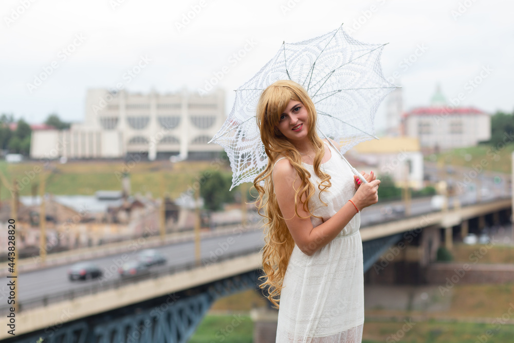A girl in a white dress with white sun umbrella