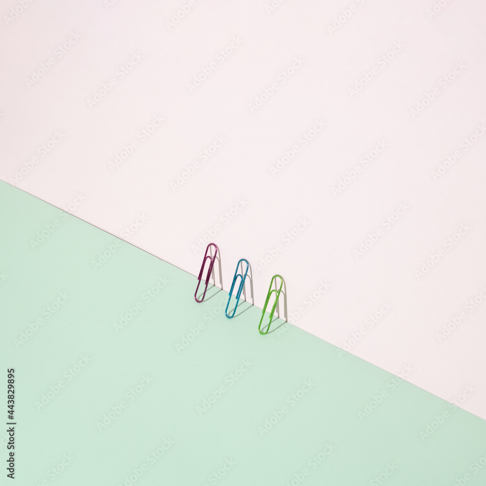 Office color paper clips on pastel pink background. Minimal concept art. Office color paper clips on pastel pink background. Minimal concept art.