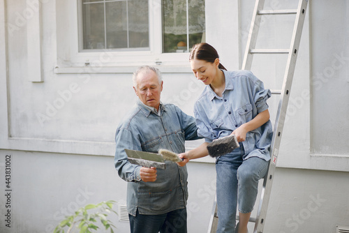 Family standing near building with repair tools