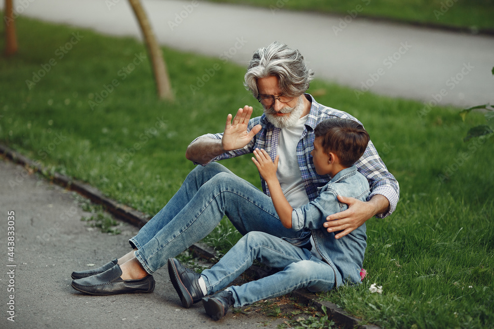 Grandfather with grandchild sitting in a summer park Grandfather with grandchild sitting in a summer park