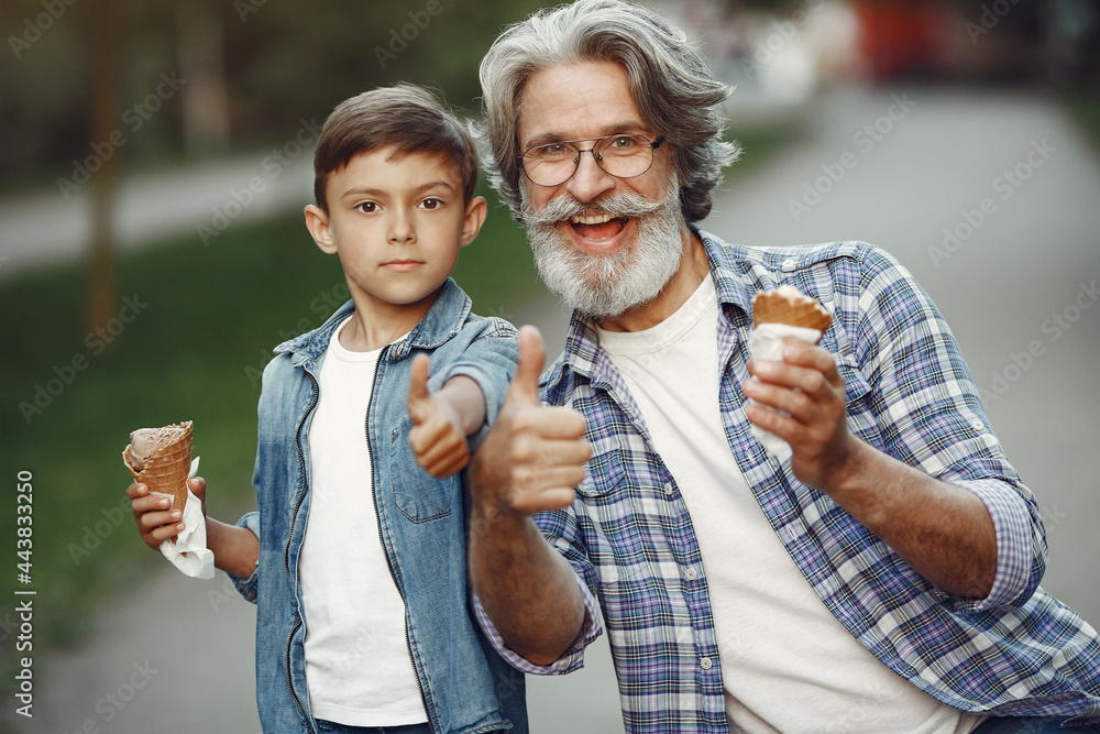 Fototapeta premium Grandfather with grandchild walking in a summer park