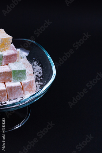 Turkish Delights in a glass bowl isolated on black background. Kurban bayrami (eid al adha), ramazan bayrami (eid al fitr) story background photo. iyi bayramlar - eid mubarak photo