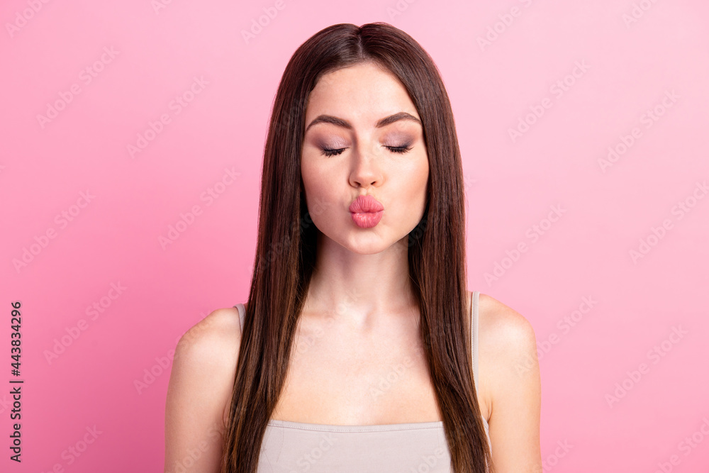 Close-up portrait of attractive dreamy girl sending air kiss amour cupid isolated over pink pastel color background Close-up portrait of attractive dreamy girl sending air kiss amour cupid isolated over pink pastel color background