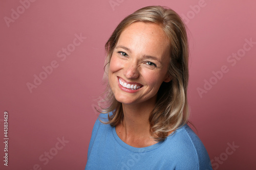 Beautiful happy commercial woman in front of a colored background