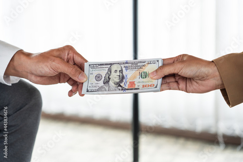 A male agent giving his greedy partner a cash for getting a favor in return