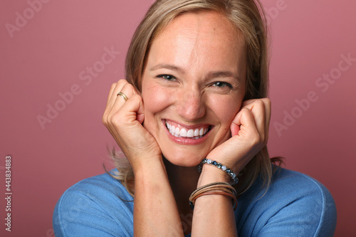 Beautiful happy commercial woman in front of a colored background