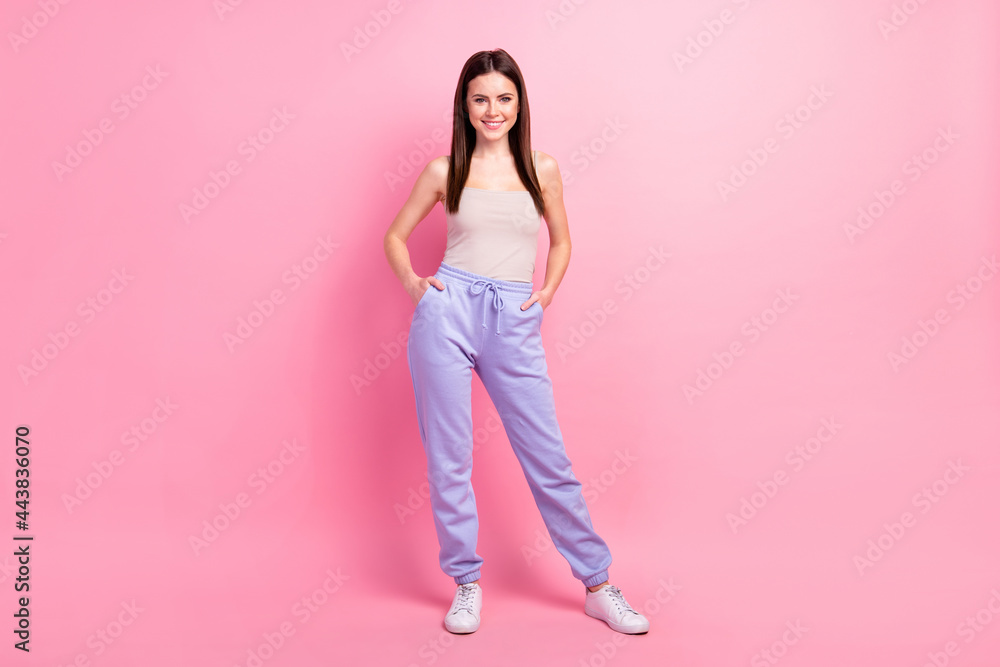 Full length photo of young attractive girl happy positive smile confident hands in pocket isolated over pastel color background Full length photo of young attractive girl happy positive smile confident hands in pocket isolated over pastel color background