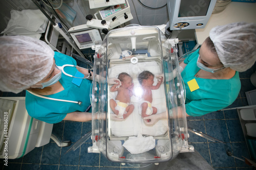 Canvas Print A children's doctor stands with a box for newborns in a children's hospital