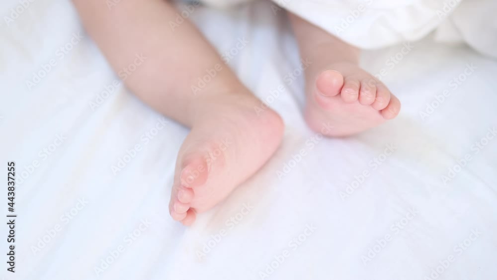 close-up view of tiny little baby infant newborn bare legs moving in the white background. close-up view of tiny little baby infant newborn bare legs moving in the white background.